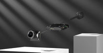 The HeadphoneHeat WalkSnail Avatar Pro Night Vision Edition HD, a compact black camera module with lens and circuit board, floats between white platforms under dramatic lighting, featuring built-in gyro hardware for enhanced stability.